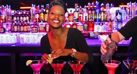 Bartender making cocktails and smiling