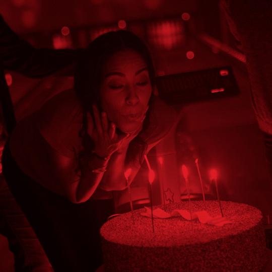 woman blowing out birthday candles on a cake