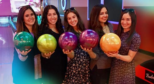 group of employees holding bowling balls