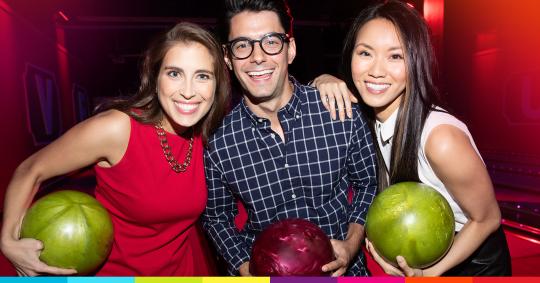 Three people holding bowling balls