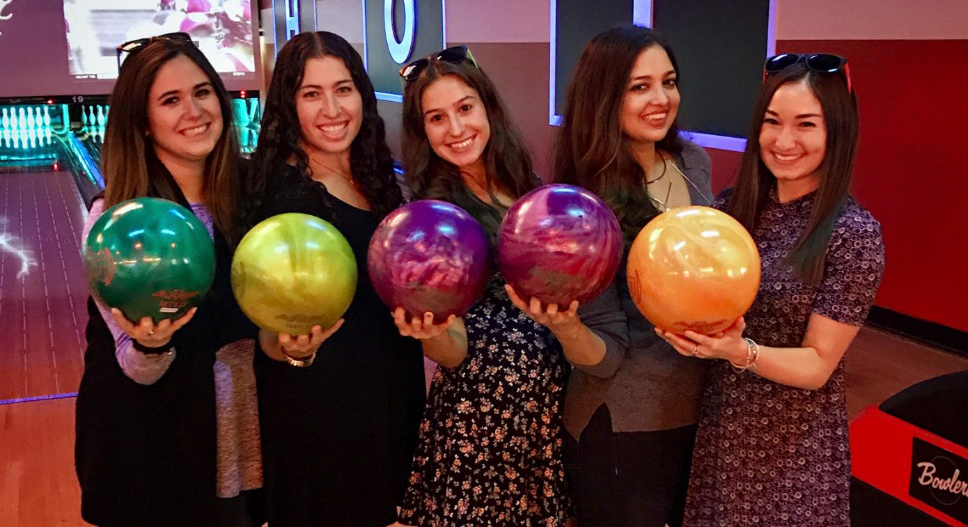 Group of women holding bowling balls