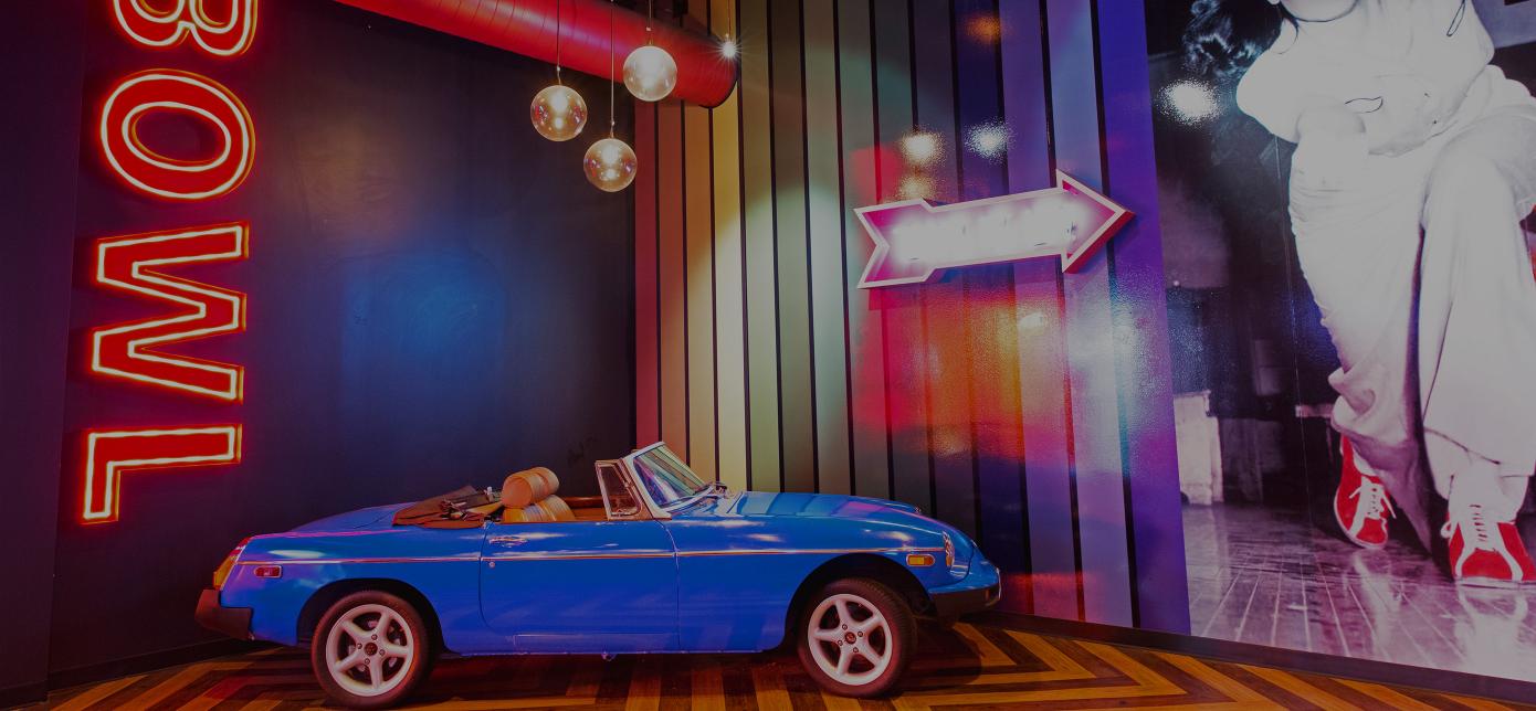 vintage car with neon bowl sign